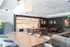 Elegant and modern open-concept clubroom with a chic kitchen, stylish dining area, and cozy seating, perfect for entertaining.