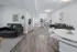 Modern open-concept living space with sleek furnishings, elegant hardwood floors, and a stylish kitchen breakfast bar.