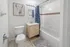 Bright and modern bathroom featuring a stylish llama artwork, elegant vanity, and cozy bathtub with a patterned shower curtain.