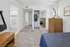 Inviting bedroom with plush carpeting, elegant wooden dressers, and ample closet space. Seamless access to bathroom and additional room enhances convenience.