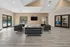 Inviting community room with modern black seating, large windows, and a view of the swimming pool outside.