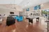 Modern communal space featuring sleek seating, expansive windows, and recreational amenities with poolside view.