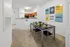 Modern apartment dining area with sleek table set for four, open kitchen, and motivational wall art for an inspiring living space.