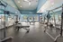 Spacious and modern gym with high ceilings, state-of-the-art equipment, and large windows offering natural light.