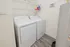 Efficient laundry space with modern washer and dryer, featuring stylish shelving for organization.