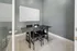 Modern conference room with sleek black table, four chairs, and a whiteboard on a stylish gray wall.