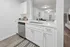 Bright contemporary kitchen with sleek white cabinetry, modern stainless steel appliances, and elegant open-concept design leading to a stylish living area.