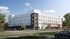 Modern four-story apartment building with sleek white and gray exterior set against a vibrant green landscaped backdrop, capturing urban sophistication and convenience.