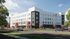 Modern four-story apartment building with sleek design, surrounded by landscaped greenery and vibrant trees, creating a welcoming community vibe.