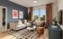 Chic living room with modern decor, featuring a stylish sofa, vibrant cushions, artful wall prints, and expansive window view.