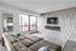 Modern living room with stylish decor, featuring a large sectional sofa, sleek fireplace, and floor-to-ceiling windows.