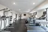 Modern gym with treadmills, weight machines, and exercise equipment in a bright, spacious room.