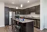 Modern kitchen with dark cabinets, stainless steel appliances, and a granite island with seating.