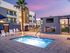 Two-Bedroom Apartments in Glendale, AZ - Acero at the Stadium - Fenced-In Outdoor Square-Shaped Hot Tub Surrounded by Concrete Tiles and White Lounge Seating.