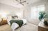 1, 2, & 3-BR Apartments In Goodyear, AZ - Acero Roosevelt - A Bright And Spacious Bedroom With A Queen Sized Bed. The Room Has White Walls And Plush Carpeting And Features A Large Window And A Ceiling Fan Above The Bed
