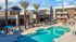 Apartments For Rent In Queen Creek, AZ - Acero Harvest Station - View From Above Of The Large Pool And Relaxing Lounge Area Surrounded By Tall Palm Trees