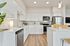 Vancouver, WA Apartments For Rent - Bennington on First - Modern, Open-Concept Kitchen With Stainless Steel Appliances, Quartz Counters, Kitchen Island, And Vinyl Plank Flooring