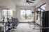 3-Bedroom Apartments in West Phoenix, AZ - Acero Roosevelt - A Modern Fitness Center with Free Weights, Strength-Training Machines, Workout Benches, Mirrors, Large Windows, and a Ceiling Fan.