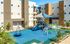 Dog-Friendly Apartments in West Phoenix, AZ - Acero Roosevelt - A Playground with Slides, Climbing Structures, Shaded Play Areas, Safety Flooring, and Surrounding Residential Buildings.