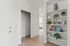 Apartments in Vancouver, WA, with In-Unit Washer and Dryer - Acero Jensen Park - A Closet Area with Built-in Shelving, D&eacute;cor, Books, a Hallway Leading to a Bedroom, and Wood-Style Flooring.