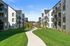 2 BR Apartments in Vancouver, WA - Bennington on First - Exterior View of Building with Parking Lot, Trees, and Landscaping.