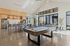 2-Bedroom Apartments in Camas, WA - Bennington on First - Bright Community Lounge With Pool Table, Bar Seating, Stainless Steel Appliances, High Ceilings, And Large Windows Overlooking Patio.