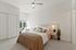 Three-Bedroom Apartments in Camas, WA - Bennington on First - Bright Bedroom With Upholstered Bed, Neutral Bedding, Ceiling Fan, Nightstands With Modern Lamps, And Large Window Seating Nook.