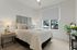 Apartments In Vancouver, WA - Bennington on First - Spacious Bedroom With A Ceiling Fan, Plush Carpet Flooring, and Connected Bathroom