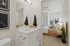Three-Bedroom Apartments in Vancouver, WA - Bennington on First - Bedroom with Carpeted Floor, Bed, Floating Nighstands with Lamps, Ceiling Fan, and Ensuite Bathroom