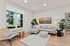 2-Bedroom Apartments in Vancouver, WA - Bennington on First - A Contemporary Living Room with a Sectional Sofa, Accent Chair, Area Rug, Side Table, and Indoor Plants.