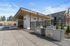 Vancouver, WA, Apartments for Rent - Bennington on First - A Grilling Area with Built-in Grills, Covered Pavilion, Lounge Seating, String Lights, and Fencing.