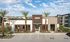 Pet-Friendly Apartments in Mesa - Acero Hawes Crossing - Exterior View of Clubhouse with Palm Trees, Parking Lot, and Landscaping