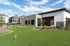 Three-Bedroom Luxury Apartments in Eastmark, AZ - Acero Hawes Crossing - Exterior Clubhouse With Putting Green, Flag Markers, Desert Landscaping, And Modern Apartment Buildings Under Blue Sky