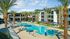 New Apartments Phoenix, AZ - Meritum Sheely Farms - Resort-Style Pool Surrounded By Lounge Chairs And Umbrellas