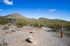 Gateway AZ Apartments with In-Unit Washer and Dryer - Meritum Sonoran Desert - An exterior shot of the vibrant desert landscape with rugged hills, scattered shrubs, and a clear blue sky