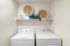 Efficient laundry room with modern washer, dryer, and artistic decor.