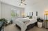 Inviting bedroom with plush bedding, stylish decor, and abundant natural light creating a serene atmosphere.
