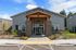 Inviting apartment entrance with modern architecture, lush landscaping, and accessible parking.