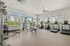 Modern fitness center with state-of-the-art equipment, abundant natural light, and spacious workout area.