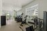 Bright and modern gym with state-of-the-art fitness equipment and large windows offering a view of the outdoors.