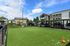 Vibrant pet-friendly apartment complex with a spacious fenced play area, surrounded by modern buildings and ample parking.