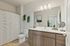 Bright and modern bathroom with sleek wooden vanity, large mirror, and elegant decor.