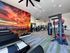 Modern fitness center featuring state-of-the-art equipment, vibrant desert mural, and spacious workout area with ample natural light.