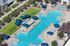 Luxurious apartment complex showcasing a sparkling swimming pool with elegant blue umbrellas and cozy lounge chairs, surrounded by well-maintained greenery.