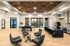 Modern open-concept living space featuring elegant wood panel ceiling, stylish gray seating area, sleek black marble kitchen island, and abundant natural light.
