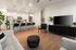 Modern open-concept living room with sleek kitchen and breakfast bar, featuring elegant decor and ample natural light.