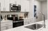 Chic and modern kitchen with sleek stainless steel appliances and elegant white cabinetry, offering a sophisticated cooking space.