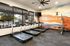 Modern fitness center with state-of-the-art treadmills facing a scenic outdoor view, complemented by an inspiring mural of a person embracing nature.