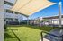 Inviting community dog park with shade sail and seating, offering a relaxing green space at the apartment complex.