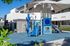 Modern apartment complex featuring a vibrant children's playground with slides and shade structures, surrounded by lush greenery.